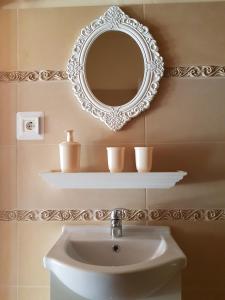 łazienka z umywalką i lustrem na ścianie w obiekcie Etyek Rustic Home w mieście Etyek