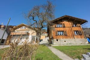 a large wooden house with a tree in front of it at Gästehaus Alpina in Fanas in Fanas