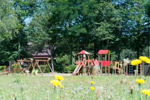 un parque con parque infantil en un campo de flores en Willa Gruszki en Narewka