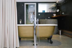 a bath tub sitting in a bathroom next to a sink at Hotel Karel in Arnhem