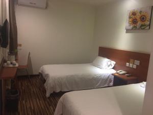 una camera con due letti in una camera d'albergo di Goldmet Inn Beojing Capital Airport Xinguozhan a Shunyi
