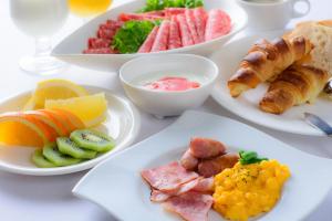 uma mesa branca com pratos de pequeno-almoço em Hotel Nets Sapporo em Sapporo