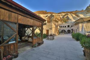 a building with a patio with a mountain in the background at Guzide Cave Hotel in Göreme