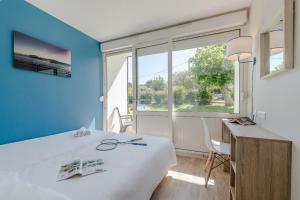 een kamer met een bed, een bureau en een raam bij Village Vacances Azureva Anglet in Anglet