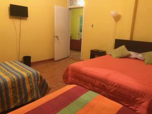a hotel room with two beds and a television at Hostal Tricontinental in Valparaíso
