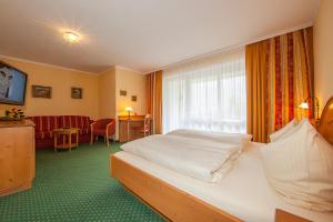 ein Hotelzimmer mit einem Bett und einem Fenster in der Unterkunft Gästehaus Lärchenhang in Mittenwald