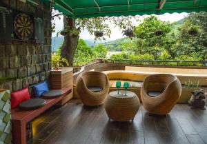 a patio with two chairs and a table with a view at Lavasa Luxury Deck Apartment in Lavasa