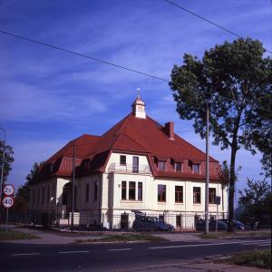 ein großes weißes Gebäude mit rotem Dach in der Unterkunft Valdi Classic in Zabrze