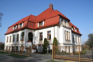 ein großes weißes Haus mit rotem Dach in der Unterkunft Valdi Classic in Zabrze