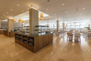 a restaurant with tables and chairs in a building at Hotel Plavi Plava Laguna in Poreč