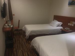 A bed or beds in a room at Goldmet Inn Beojing Capital Airport Xinguozhan