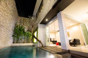 a house with a swimming pool in the middle of a house at InKuta Residence and Villa in Seminyak