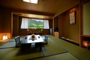 a room with a table and chairs and a window at Wakamatsuya in Zaō Onsen