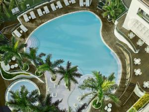 an overhead view of a swimming pool with palm trees at Mövenpick Hotel Mactan Island Cebu in Mactan