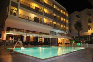 una piscina frente a un hotel por la noche en Saint Constantine Hotel, en Cos