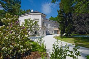 un grande edificio bianco con alberi e fiori di Zámek Ratměřice - Hotel & Resort a Ratměřice