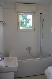 a bathroom with a tub and a sink and a window at Residence Art Split in Podstrana +23 photos