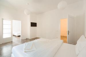 ブラショヴにあるM&F Apartmentの白いベッドルーム(白いシーツを使用した大型ベッド1台付)
