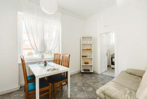 Una sala de estar con una mesa y sillas y un sofá. en M&F Apartment, en Brasov