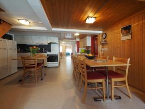a kitchen with wooden walls and a table and chairs at Esthers Guesthouse in Gimmelwald