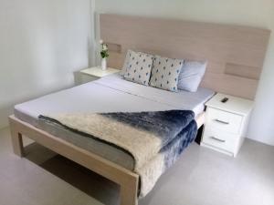 a bedroom with a large bed with a wooden headboard at Sergi's Resort and Hotel in Palompon