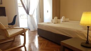 アテネにあるErrathens Vanilla Apartment - Athens Centerのベッドルーム1室(ベッド1台、椅子、ランプ付)