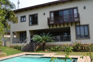 a house with a swimming pool in front of it at Mahogany House - SOLAR POWERED in Ballito