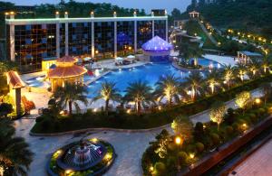 un complejo con una gran piscina por la noche en Shenzhen Baohengda International Hotel, en Longgang