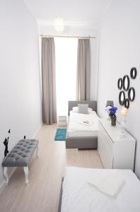 Apartament Pod Kopernikiem II في تورون: غرفة معيشة بيضاء مع أريكة وطاولة