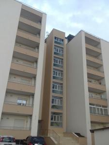 two apartment buildings with cars parked in front of them at Palazzo del Mare in Naples