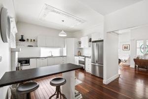 a kitchen with white cabinets and a black counter top at The Lighthouse in Toowoomba