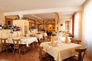 une salle à manger avec des tables et des chaises blanches dans l'établissement Hotel Mediterraneo, à Neustadt an der Weinstraße