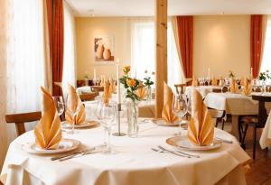 une salle à manger avec des tables et des nappes blanches dans l'établissement Hotel Mediterraneo, à Neustadt an der Weinstraße