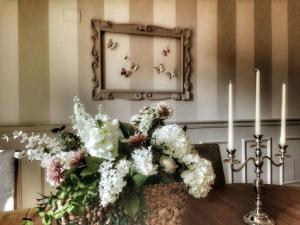 a table with two candles and a mirror with flowers at c'è posto per te in Vasto