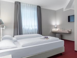 a hotel room with two beds and a window at Coffee Fellows Hotel Siegburg West in Siegburg