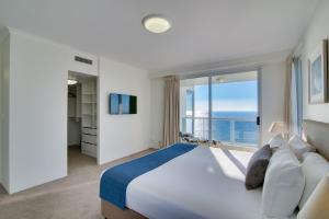 a bedroom with a large bed and a large window at Xanadu Resort in Gold Coast
