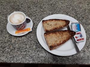 a plate with two pieces of toast and a cup of coffee at A Concha in Lavacolla