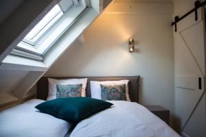 ein Schlafzimmer mit einem Bett und einem Fenster im Dachgeschoss in der Unterkunft De Verloren Sinjoor in Bladel