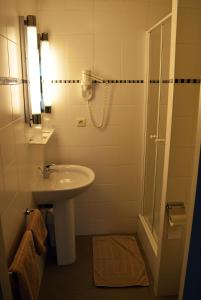 uma casa de banho com um lavatório e um chuveiro em Hotel De Schacht em Genk