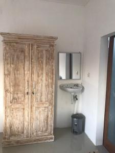 a bathroom with a wooden cabinet and a sink at D'Canggu Homestay in Canggu +44 photos