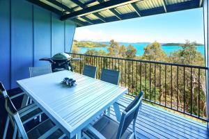 a white table and chairs on a balcony with a view at Panorama Apartments on Hamilton Island by HIHA in Hamilton Island