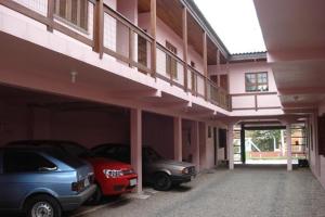 two cars parked in a parking lot in a building at Pousada Tuiuti in Tramandaí