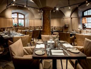 ein Restaurant mit Tischen und Stühlen in einem Zimmer in der Unterkunft Platzl Hotel - Superior in München