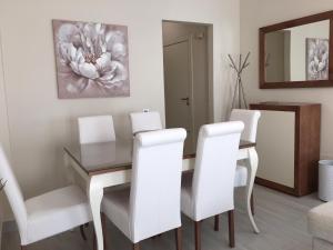 a dining room with a table and white chairs at New Apartments Ronda in Ronda