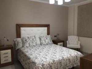 a bedroom with a bed and a chair at New Apartments Ronda in Ronda