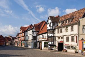 a row of white and black buildings on a street at Hotel Pension St Nikolai in Quedlinburg
