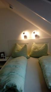 ブラウンラーゲにあるFewo Schröder - Harzflairのベッドルーム1室(ベッド2台、枕、照明付)