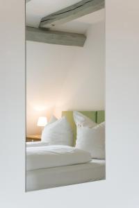 ein Schlafzimmer mit einem Bett mit weißen Kissen in der Unterkunft Hotel Pension St Nikolai in Quedlinburg