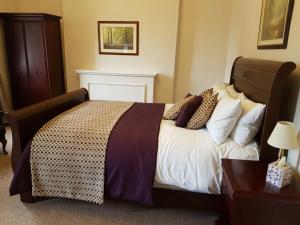 a bedroom with a large bed with pillows on it at The Greyhound Hotel Cromford in Cromford