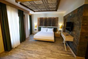 a bedroom with a bed and a desk and a television at Gelibolu Taş Konak Hotel in Gelibolu